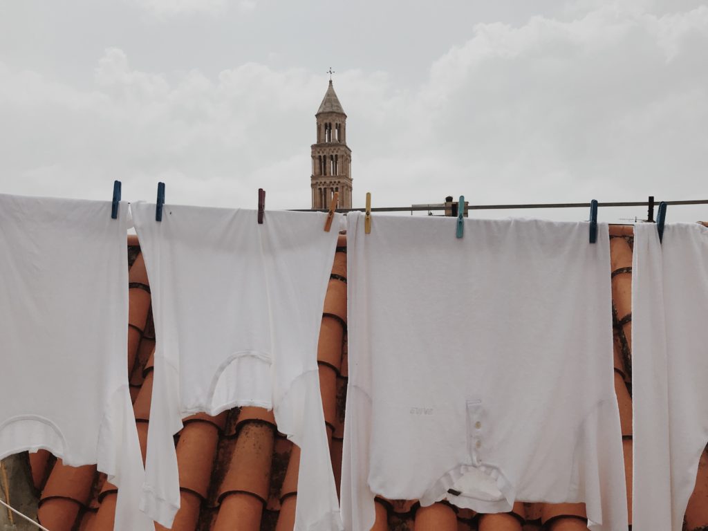 Clean clothes (laundry) hanging from a dryer outside, shaken by the wind