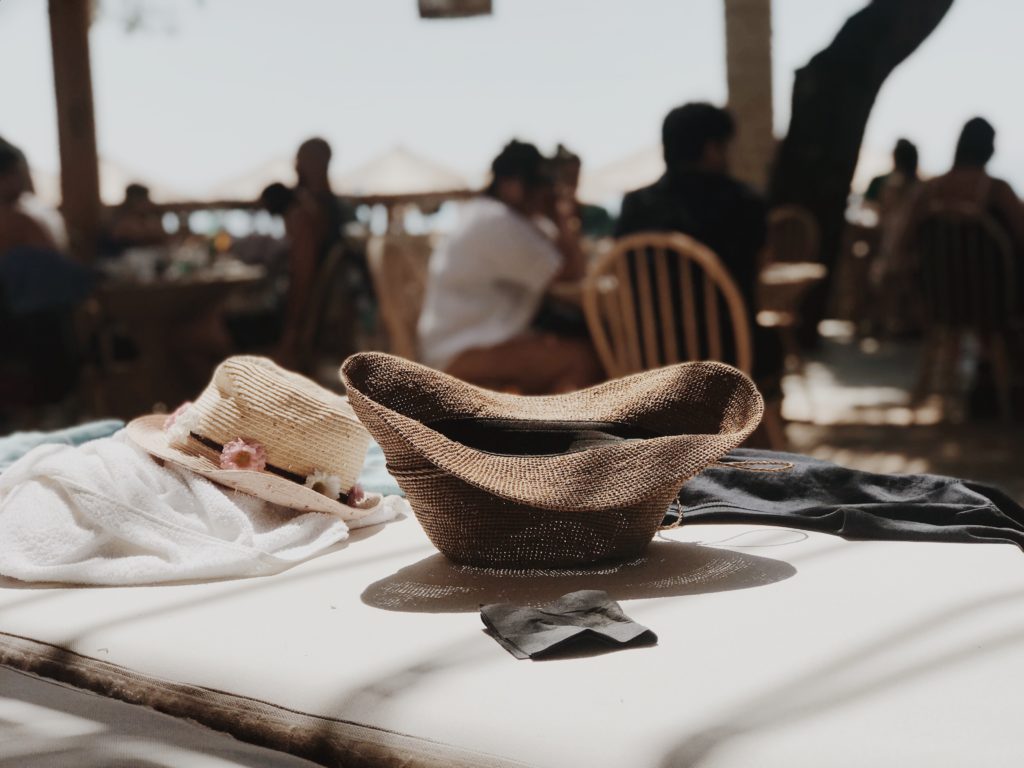 Fashion Women Summer Straw Beach Hat in a cafe on the beach