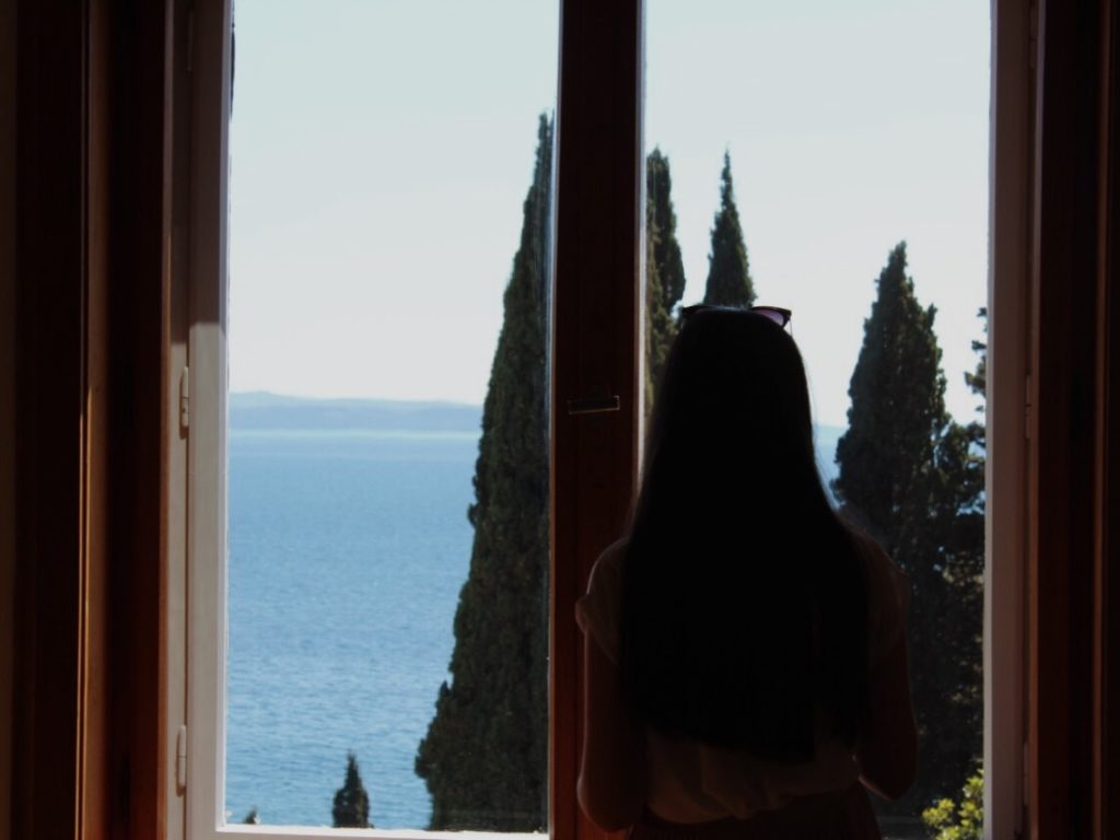 A girl watching the sea through the window