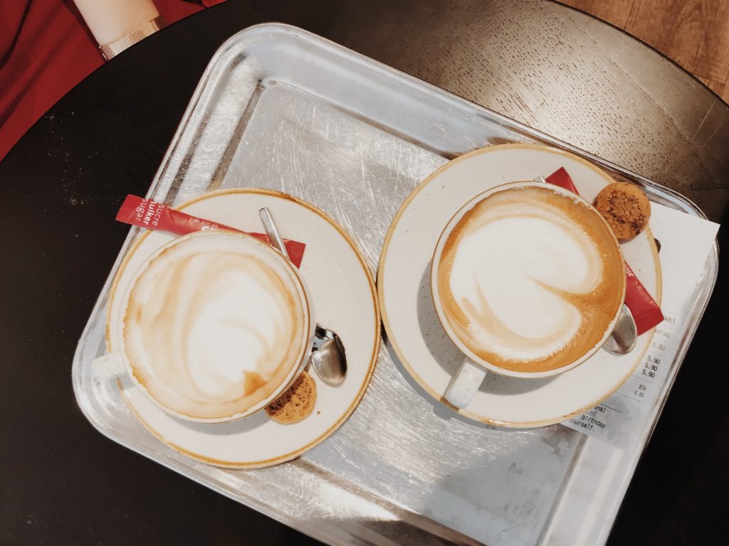 Two cups of coffee on white wooden table. Top view