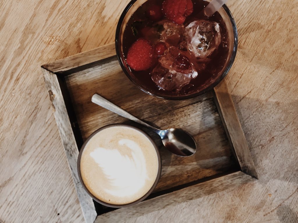 The ordered coffee is served in a wooden tray, a little bit hipster