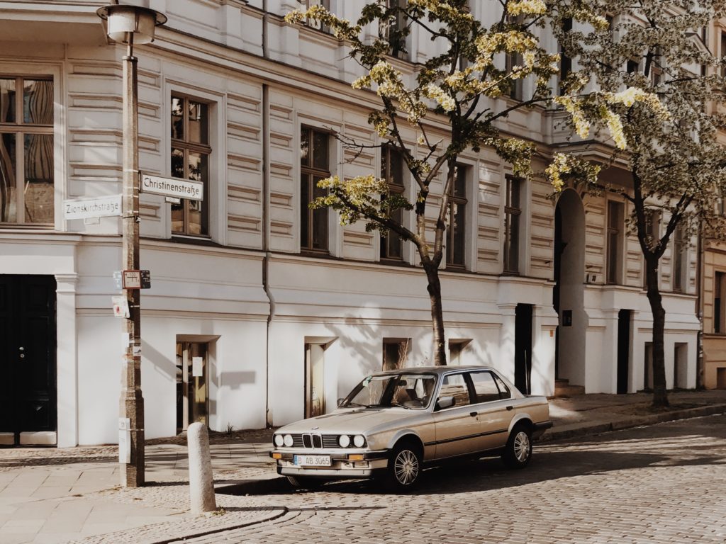 BMW at springtime in Berlin, Germany. blossoming tree on the foreground, focus on blossom tree flowers