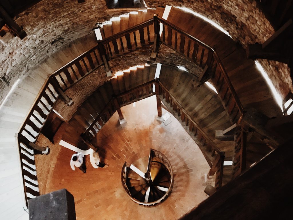 nside of an old brick tower with a wooden stairs