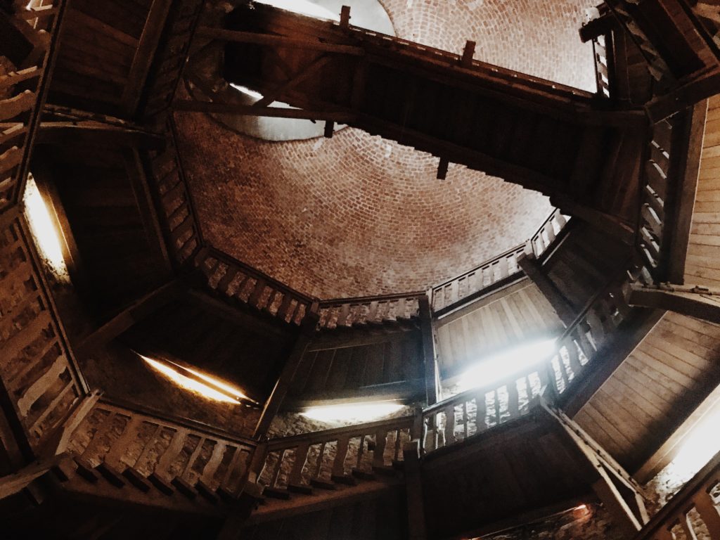 nside of an old brick tower with a wooden stairs