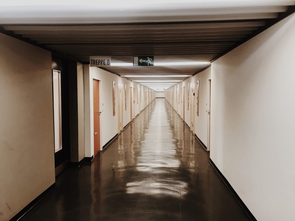 Short corridor with the white walls and black floor