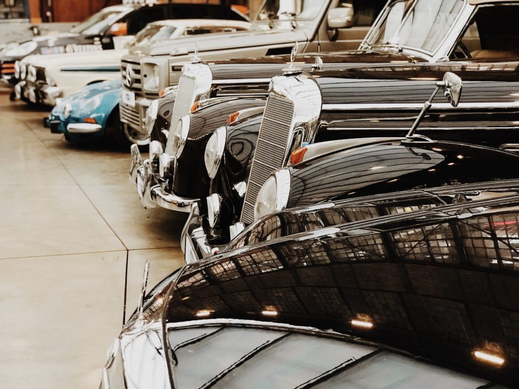 A row of Mercedes Benz vintage cars lined up in a car showroom