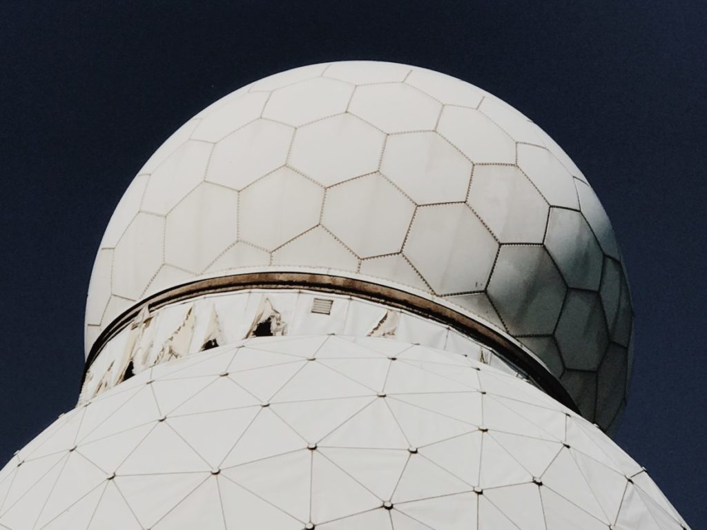 An empty building and geodesic dome at the listening station are covered with various murals