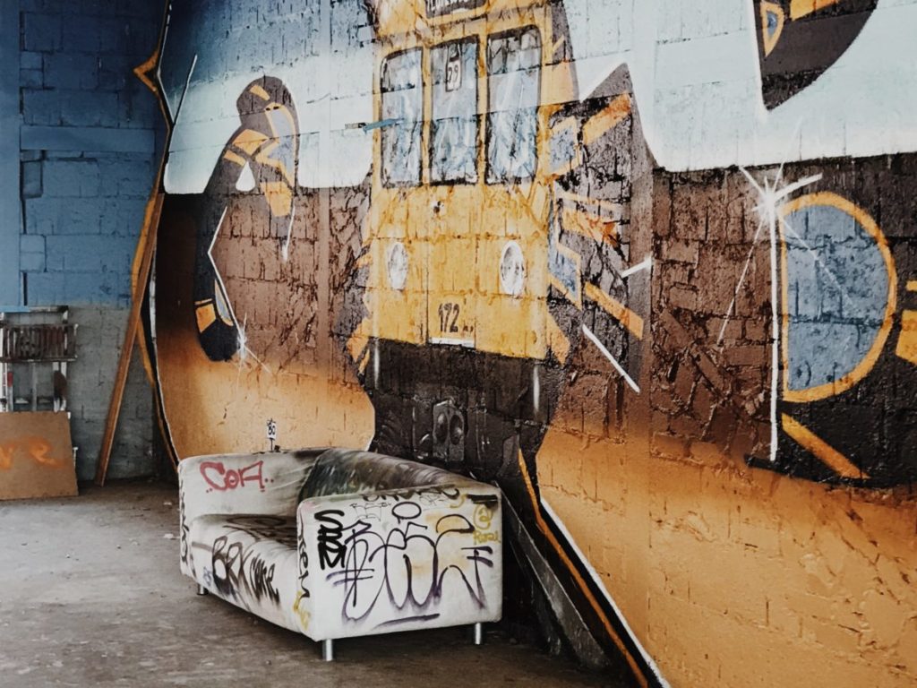 Sofa covered with graffiti with street art background