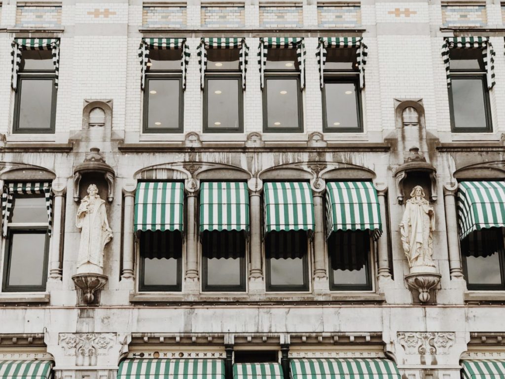 Facade contains a white glazed brick with many decorations and statues of Art-Nouveau style